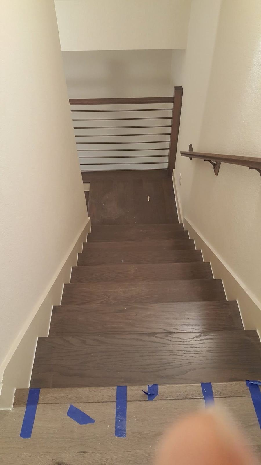 Staircase descending with a modern horizontal rod railing system